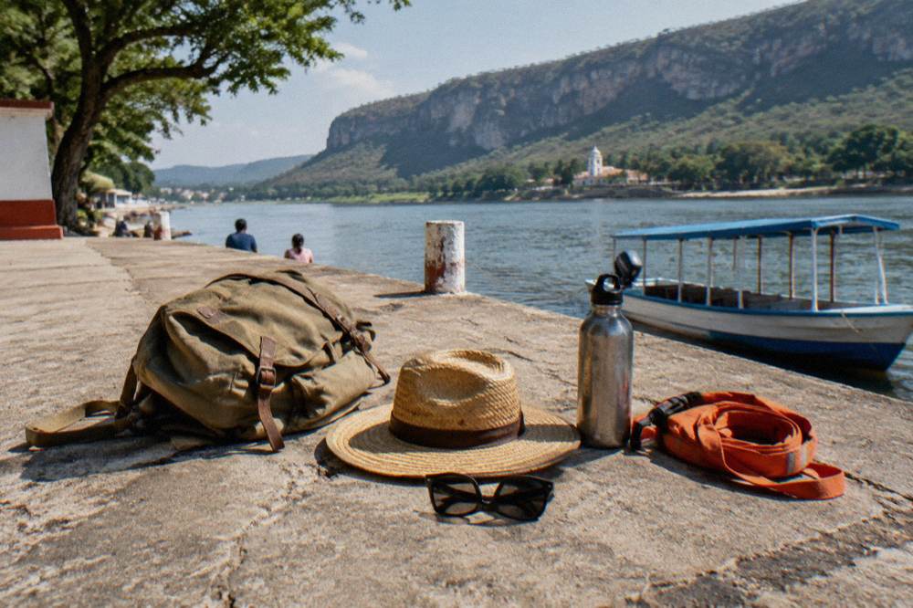 A canvas daypack, wide-brim hat, sunglasses and water bottle arranged on a wooden bench