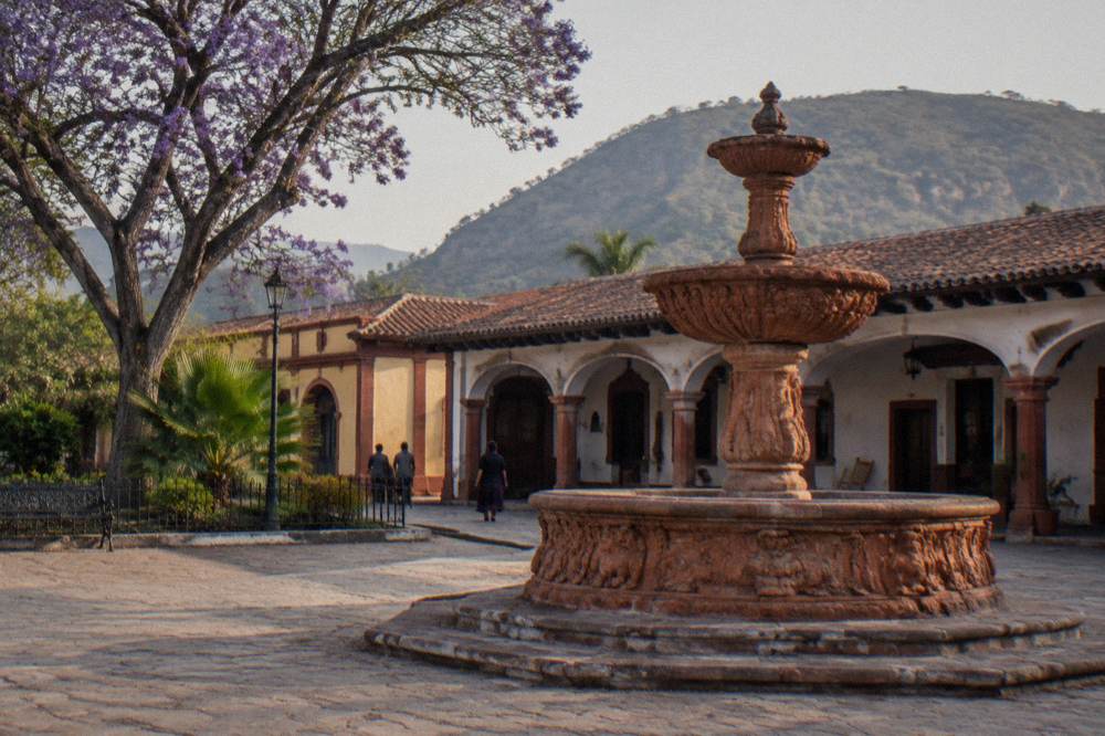 Colonial arcade and fountain square in a small Mexican town in soft morning light