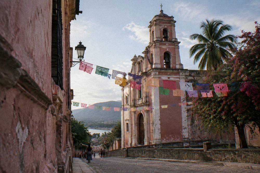 Colonial church facade and festival bunting above a Chiapas town street