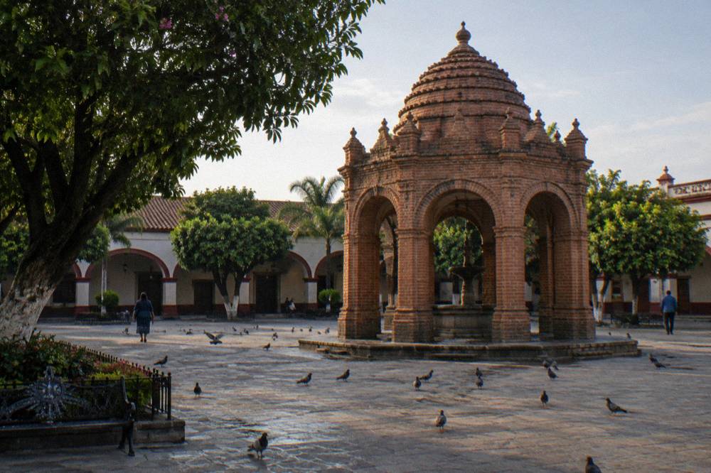Brick fountain and arcaded plaza buildings in Chiapa de Corzo on a quiet morning