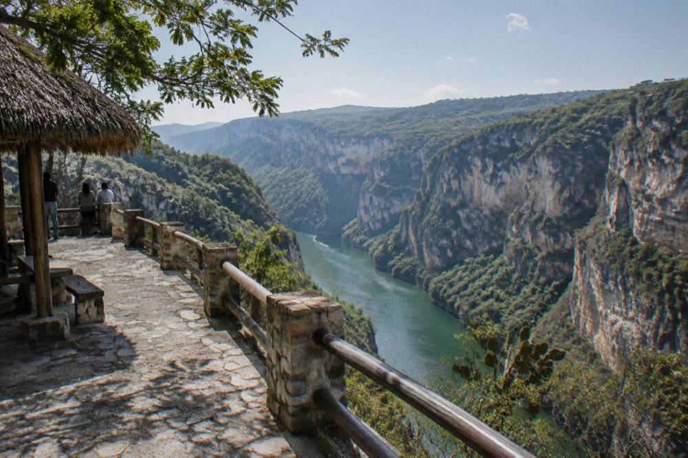 A stone viewpoint terrace overlooking a deep canyon with a river far below