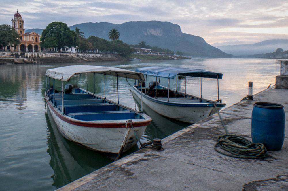 River dock jetty in morning light with moored small boats and calm water