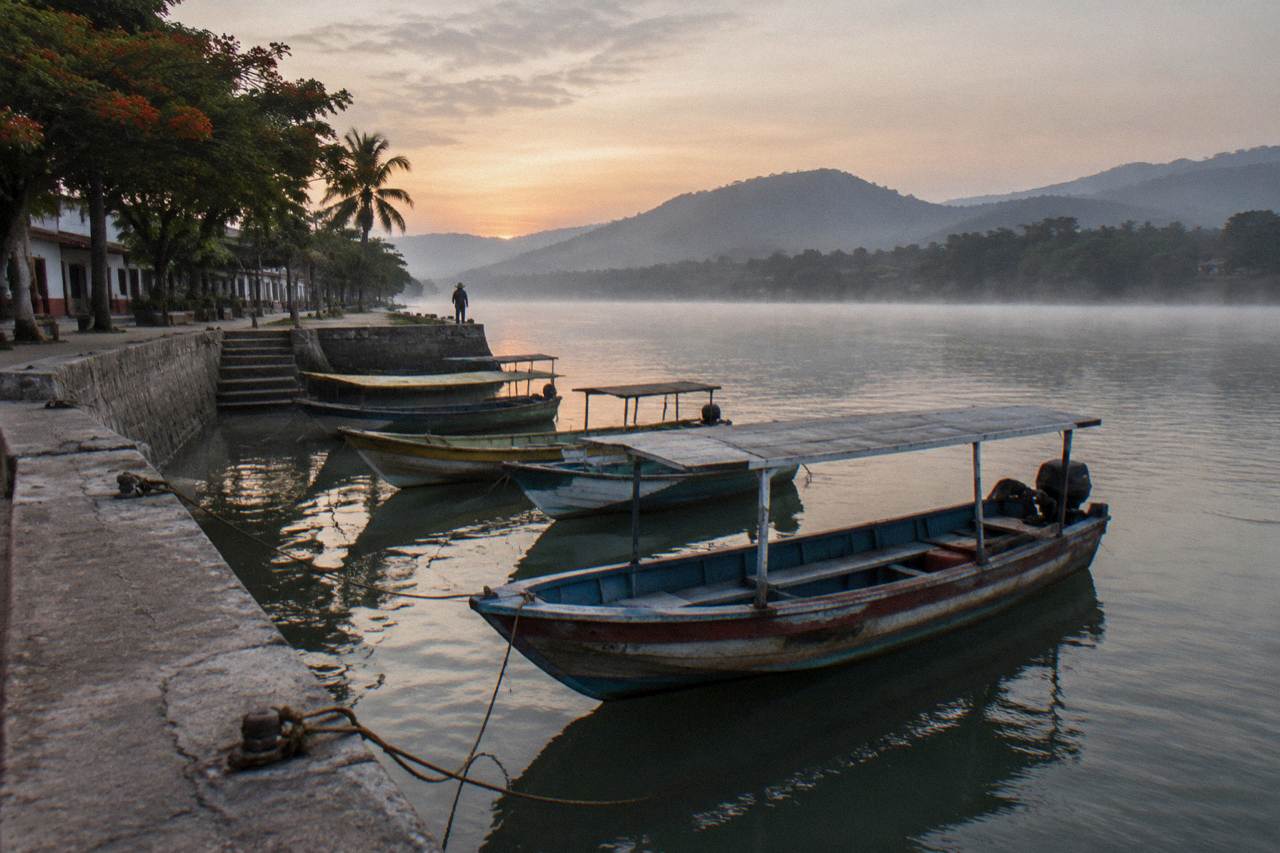 Wooden boats moored along the Grijalva River below the waterfront of Chiapa de Corzo