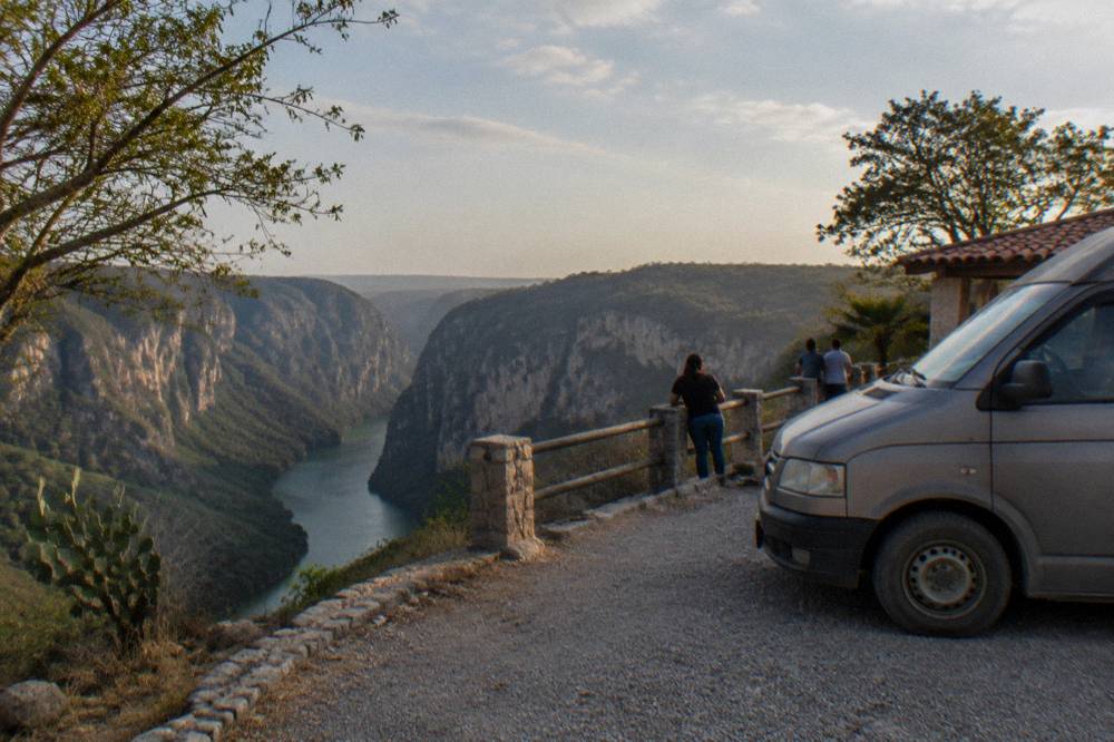 Van parked on a roadside viewpoint overlook above a deep river canyon