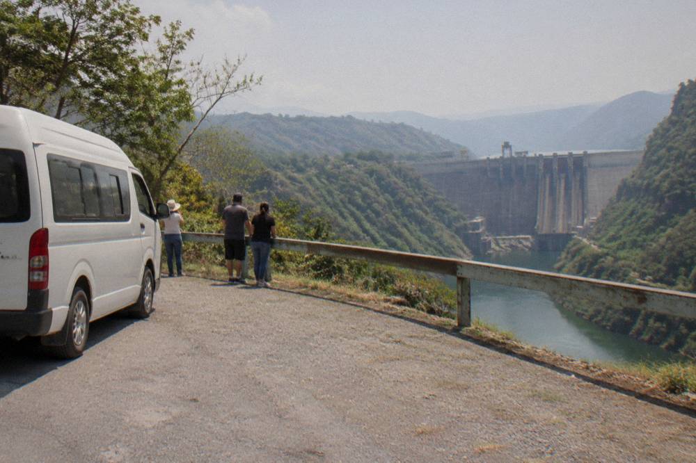 A van parked on a roadside overlook above a deep river gorge